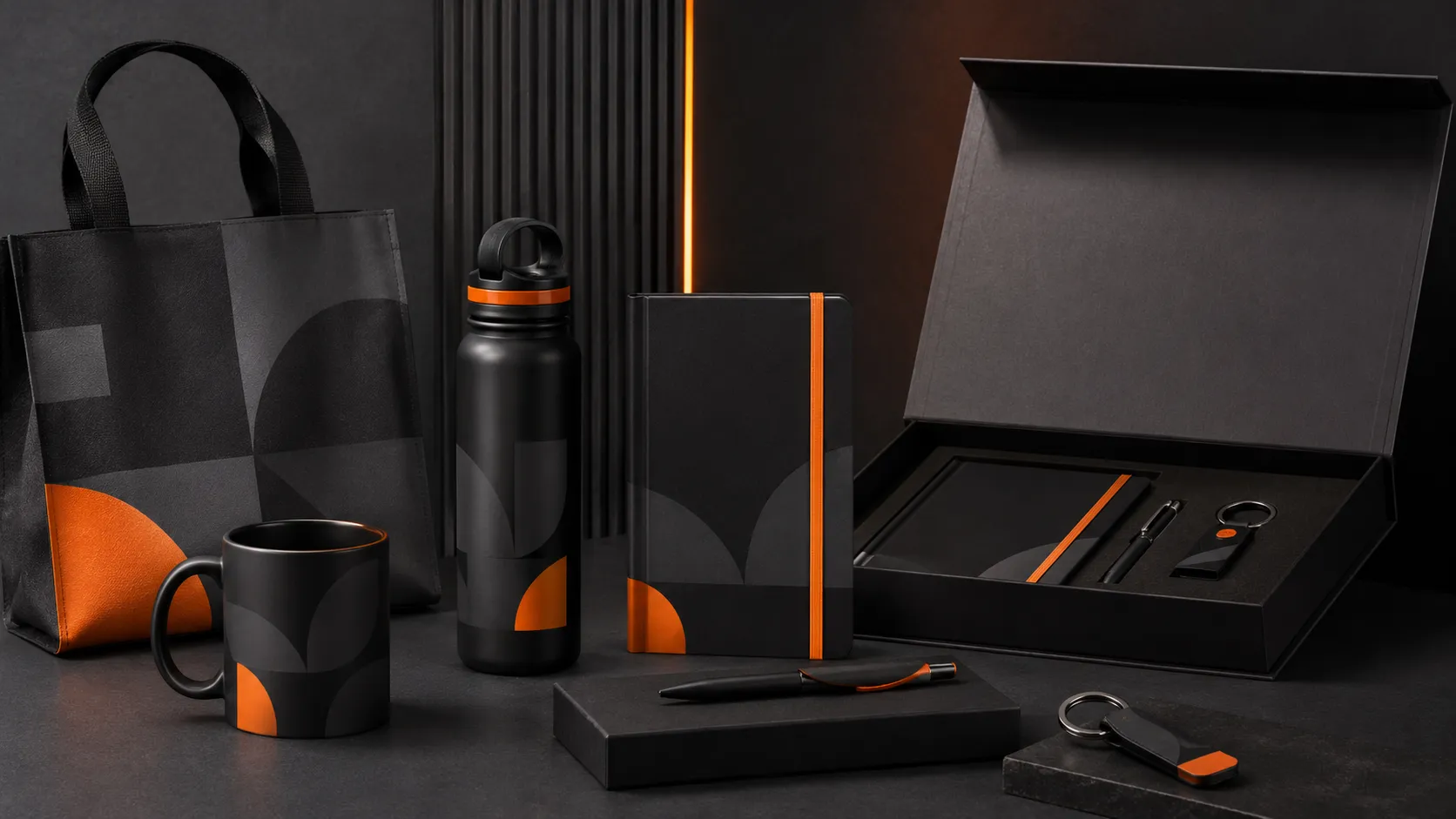 Conjunto premium de brindes corporativos, como agendas, canetas metálicas e squeezes pretas com gravação sutil da logo em laranja e grafite